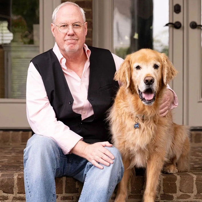 A man sitting on the steps with his dog.